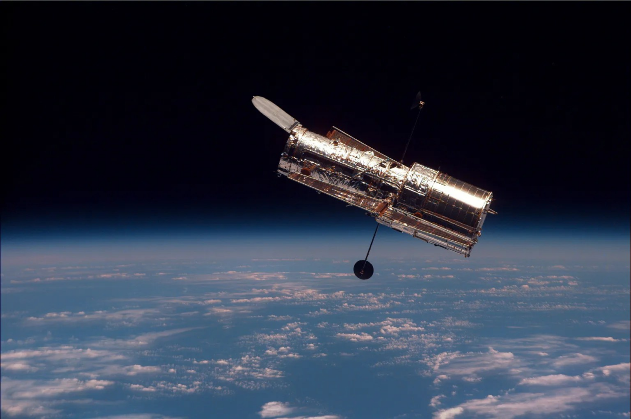 Hubble Space Telescope above Earth's clouds and atmospheric limb. NASA photograph supplied in the website requirements.