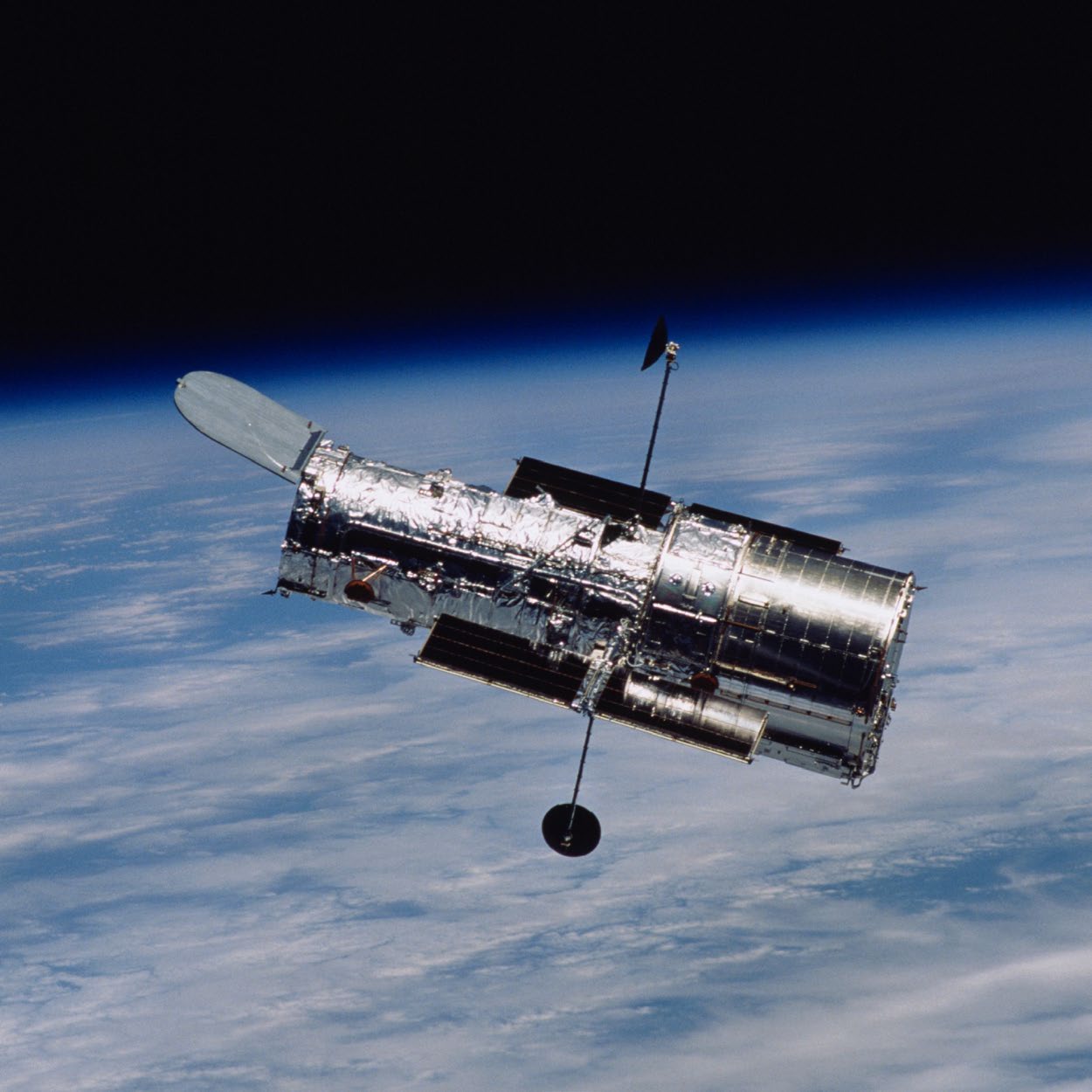 Hubble Space Telescope in orbit above Earth, as shown in the paper's instrument figure.
